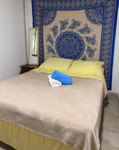 a bedroom with a bed with a blue and yellow headboard at Casa da Mata Madalena in Angra dos Reis