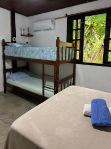 a bedroom with two bunk beds and a window at Casa da Mata Madalena in Angra dos Reis
