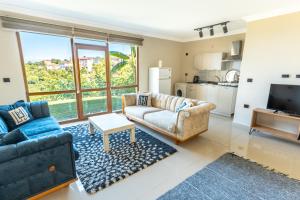 a living room with a couch and a tv at Natural Villas Trabzon in Komera
