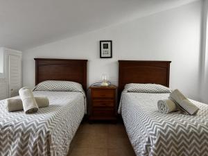 two beds sitting next to each other in a bedroom at Casa Los Barberos in Valle de Abdalagís