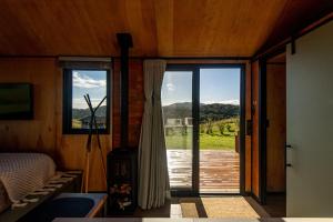 a bedroom with a sliding glass door with a view at Tiny House - Rancho Queimado SC - 15 Min do centro in Rancho Queimado +19 photos