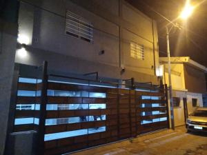 a fence in front of a building at night at Apart Trelew 1 in Trelew