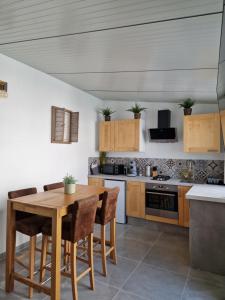 a kitchen with a wooden table and chairs at Maisonnette à 350m de la plage in Berck-sur-Mer