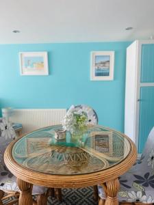 a glass table with flowers on it in a room at Margate Summerhouse in Westgate-on-Sea