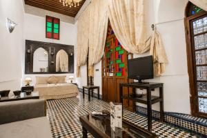 a living room with a couch and a tv at Riad Noujoum Medina Fez in Fez