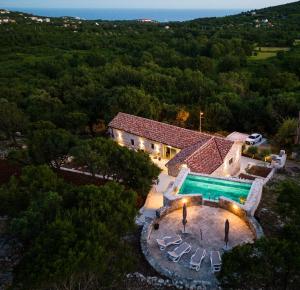 an aerial view of a house with a swimming pool at Heritage House Strahinja Stone Villa with Private Pool in Popovići