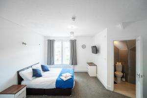a bedroom with a large bed with blue pillows at The Bitterne Park Hotel in Southampton