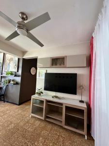 a living room with a flat screen tv on a table at Isla Verde By The Beach Guest House in San Juan
