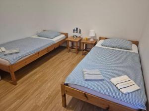 two twin beds in a room with wooden floors at Apartments Jasmina in Novalja +55 photos