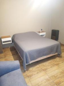 a bedroom with a bed and a wooden floor at Apart Trelew 3 in Trelew