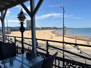 a view of a beach from a restaurant with a table and chairs at Margate Summerhouse in Westgate-on-Sea