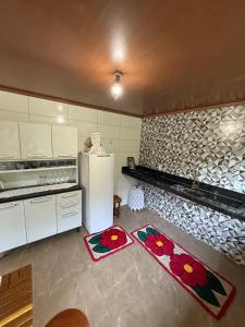 a kitchen with a refrigerator and two mats on the floor at Recanto Pin in Alfredo Chaves +6 photos
