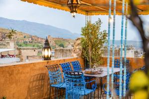 a table and chairs on a balcony with a view at Riad Noujoum Medina Fez in Fez