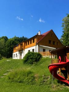 a house and a playground in front of a house at Apartmány Bramborka in Janov nad Nisou