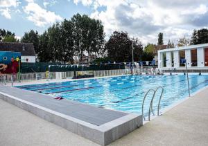 a large swimming pool with blue water at L'Étoile in Moret-sur-Loing