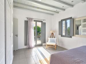 a bedroom with a bed and a chair at SeaSalt Dream Villa,Santa Maria 5 min from Naousa in Santa Marina +38 photos