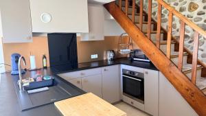a kitchen with a black counter top and a staircase at Villa d'Aneta in Le Poët