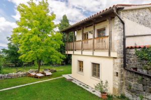 a house with a balcony on the side of it at Krasna Hiška - Authentic Heritage Home in Sežana
