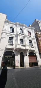 a man standing in front of a white building at Lima Centro Apartment 3 in Lima