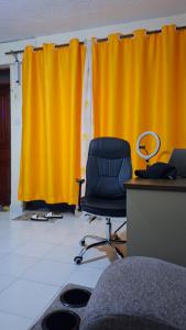 an office with a chair and a yellow curtain at Boston apartments in Kakamega