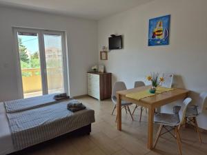 a room with a bed and a table and chairs at Apartments Jasmina in Novalja