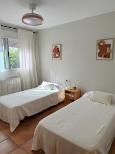 a bedroom with two beds and a window at Azul Calma in Vinarós +8 photos