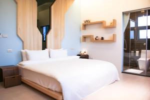 五結鄉的住宿－晴川禾悅休閒會館，卧室设有一张白色大床和一扇窗户。