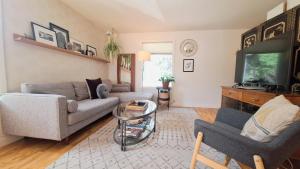 a living room with a couch and a tv at Charming Inner City Home in Calgary