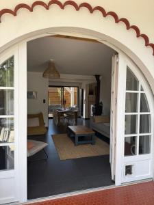 an archway leading into a living room with a table at Belle maison basco landaise avec jacuzzi in Labenne