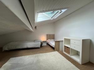a attic bedroom with a bed and a skylight at Belle maison basco landaise avec jacuzzi in Labenne