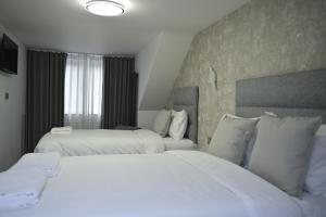 a hotel room with two beds and a stone wall at Lavender Guest House, Near Royal Infirmary, Edinburgh in Edinburgh