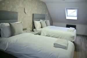 a hotel room with two beds with white sheets at Lavender Guest House, Near Royal Infirmary, Edinburgh in Edinburgh