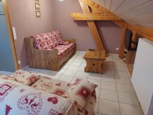 a room with a bed and a chair and a table at gite des granges bailly in Les Fourgs +2 photos