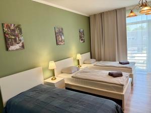 two beds in a room with green walls at Apartmány Lavender 2 in Nova Dedinka