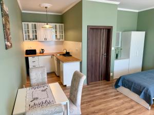 a kitchen and a bedroom with a bed and a table at Apartmány Lavender 2 in Nova Dedinka