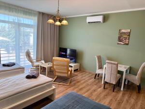 a room with two beds and chairs and a television at Apartmány Lavender 2 in Nova Dedinka