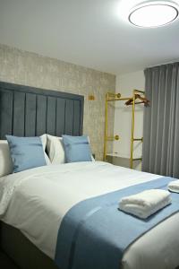 a bedroom with a large bed with blue and white pillows at Lavender Guest House, Near Royal Infirmary, Edinburgh in Edinburgh