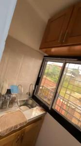 a small kitchen with a sink and a window at Angevita City1 in Edéa