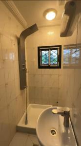 a bathroom with a sink and a tub with a window at Angevita City1 in Edéa