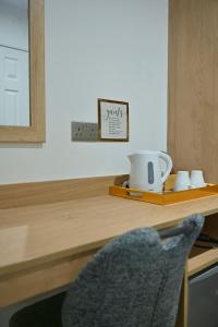 a desk with a chair and a sign on a counter at Lavender Guest House, Near Royal Infirmary, Edinburgh in Edinburgh +19 photos