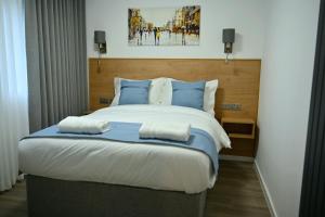 a bedroom with a large bed with blue pillows at Lavender Guest House, Near Royal Infirmary, Edinburgh in Edinburgh