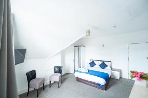 a bedroom with a bed and two chairs at The Bitterne Park Hotel in Southampton +63 photos