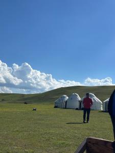 a man standing in a field next to tents at House in Kyzart
