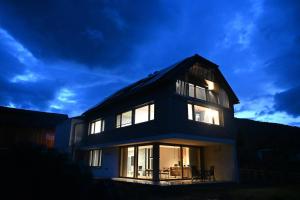 a large house with lights on in the evening at Haus Preber in Mariapfarr