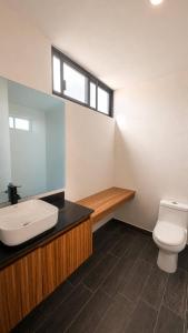 a bathroom with a toilet and a sink and a window at Bowra World Cup House, Akron Stadium 5 in Guadalajara