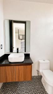 a bathroom with a sink and a mirror and a toilet at Bowra World Cup House, Akron Stadium 5 in Guadalajara