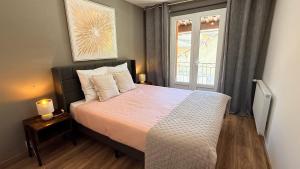a bedroom with a large bed and a window at Chez Aneta in Sisteron