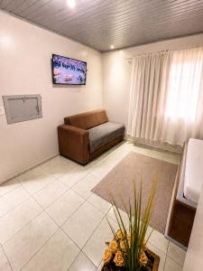 a living room with a couch and a window at Angico Motel in Passo Fundo