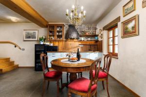 a kitchen with a table with chairs and a chandelier at Krasna Hiška - Authentic Heritage Home in Sežana