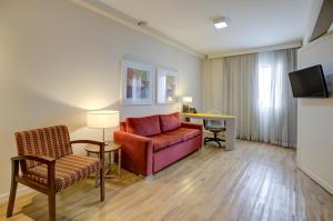 a living room with a couch and a chair at Quality Suites Alphaville in Barueri